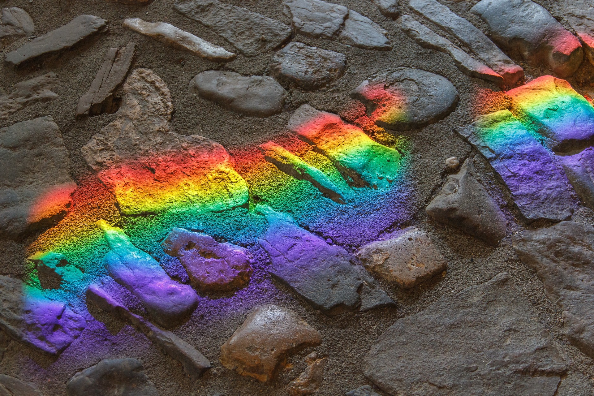 Reflexion eines Regenbogens auf Pflastersteinen