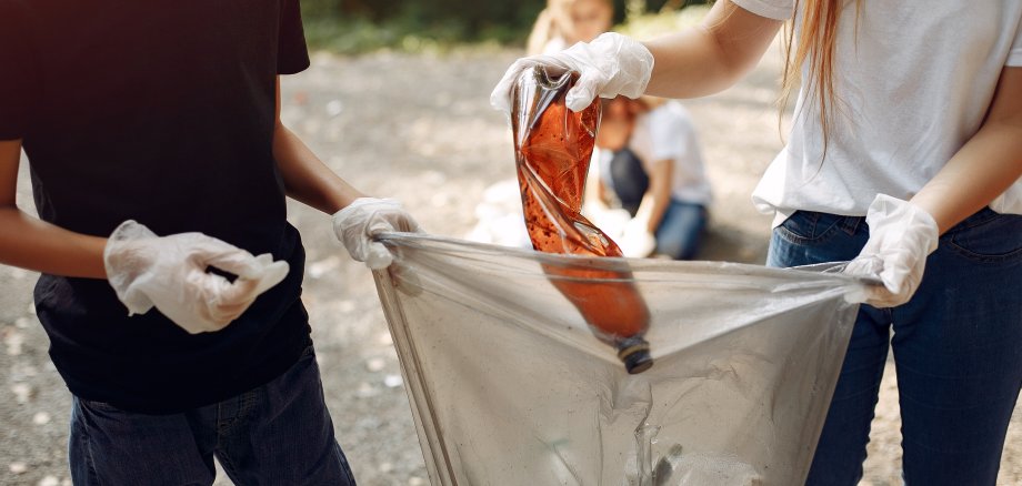 Children collects garbage in garbage bags in park